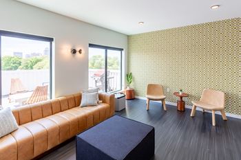 A living room with a brown sofa and a black table.at Rowat Lofts, Iowa   